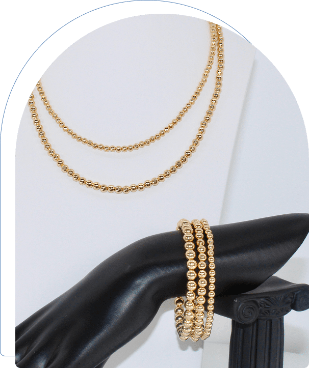 Elegant gold chain necklace and bracelet displayed on a black mannequin hand.